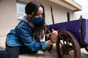 Marisa Cardinalli paints wagon with cardinal logo